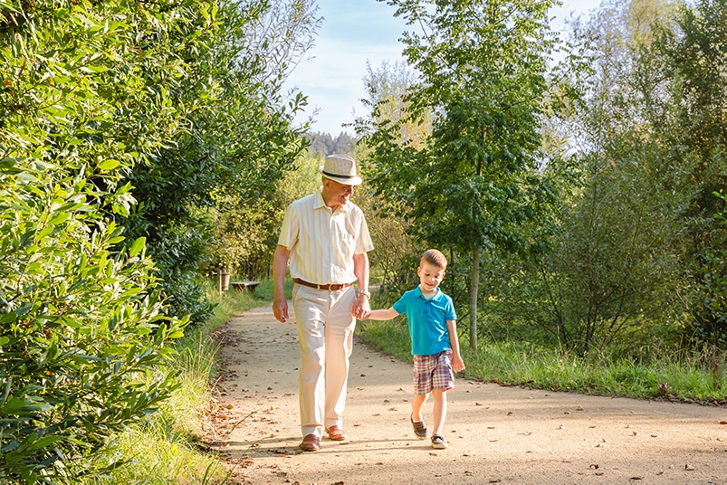 An older man walking with his grandson